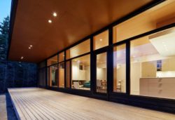 Terrasse bois et grande baie vitrée vue salon - Lockeport-Beach-House par Nova Tayona Architects - Nouvelle-Ecosse, Canada © Janet Kimber
