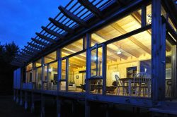 Façade entièrement vitrée illuminée - Glass-Cabin par atelierRISTING - Fairbank, USA © Steven