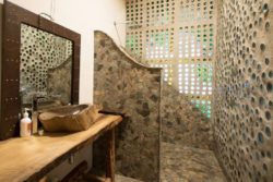 Salle de bains avec façade bouteilles recyclées - Earthship Te Timatanga par Gus-Sarah - Waikato, Nouvelle-Zelande