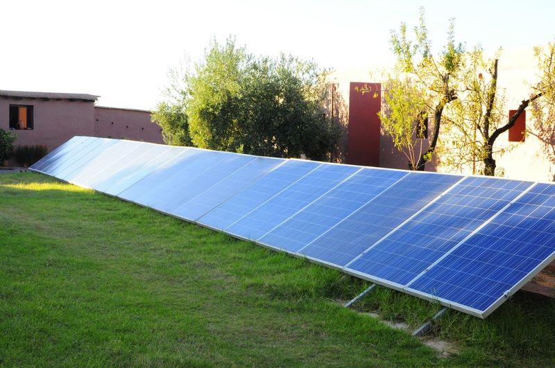 panneaux photovoltaïques posés au sol pour faciliter leur entretien, mais aussi leur arrosage et bénéficier de l'évapo-transpiration du gazon